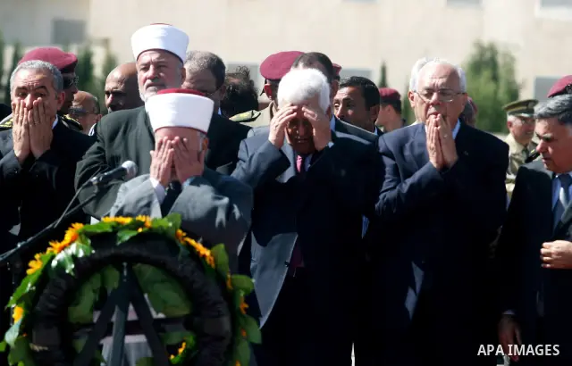 Palestinians pray over flag-draped coffins during the funeral of 91 Palestinians whose remains were returned by Israel at the Palestinian leadership headquarters in the West Bank city of Ramallah on May 31, 2012. Israel...