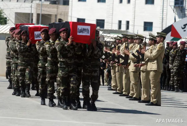 Palestinian Presidential guards carry flag-drapped coffins containing the remains of Palestinian militants during an official ceremony at the President's headquarter in the West Bank town of Ramallah, 31 May 2012. Israel...