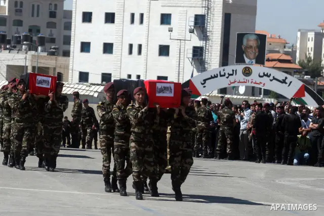 Palestinian Presidential guards carry flag-drapped coffins containing the remains of Palestinian militants during an official ceremony at the President's headquarter in the West Bank town of Ramallah, 31 May 2012. Israel...