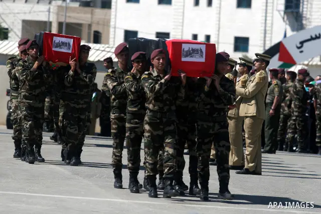 Palestinian Presidential guards carry flag-drapped coffins containing the remains of Palestinian militants during an official ceremony at the President's headquarter in the West Bank town of Ramallah, 31 May 2012. Israel...