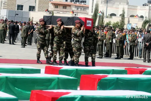 Palestinian Presidential guards carry flag-drapped coffins containing the remains of Palestinian militants during an official ceremony at the President's headquarter in the West Bank town of Ramallah, 31 May 2012. Israel...