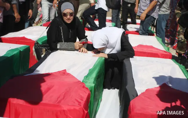 Palestinian woman mourn over a flag-draped coffin prior to the funeral of 91 Palestinians whose remains were returned by Israel at the Palestinian leadership headquarters in the West Bank city of Ramallah on May 31, 2012...