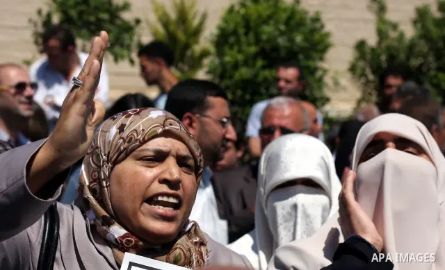 Relatives react as they carry flag-drapped coffins containing the remains of Palestinian militants dafter an official ceremony at the President's headquarter in the West Bank town of Ramallah, 31 May 2012. Israel handed...