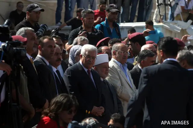 Palestinians pray over flag-draped coffins during the funeral of 91 Palestinians whose remains were returned by Israel at the Palestinian leadership headquarters in the West Bank city of Ramallah on May 31, 2012. Israel...