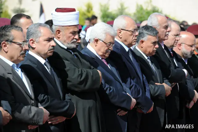 Palestinian President Mahmoud Abbas prays with officials over flag-draped coffins during an official ceremony marking the return of the remains of dozens of Palestinians militants in the West Bank city of Ramallah May 31...