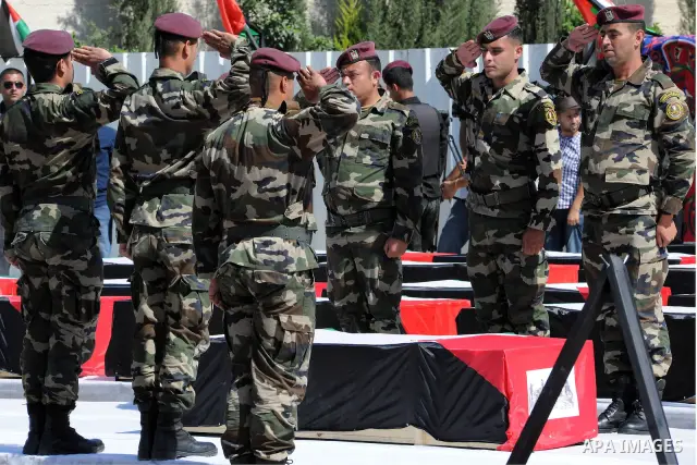 Members of the Palestinian security forces carry flag-covered coffins containing the remains of Palestinian militants during an official ceremony in the West Bank city of Ramallah May 31, 2012. The remains of 91 Palestin...