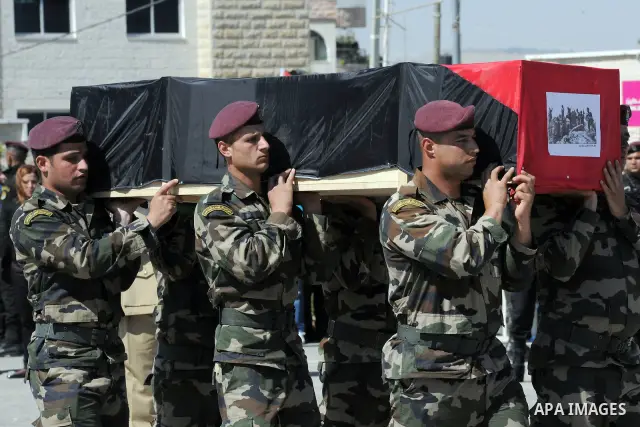 Members of the Palestinian security forces carry flag-covered coffins containing the remains of Palestinian militants during an official ceremony in the West Bank city of Ramallah May 31, 2012. The remains of 91 Palestin...