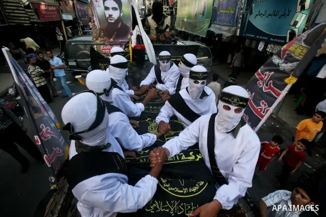 Masked Palestinian militants carry flag-drapped coffins containing the remains of Palestinian militants that were handed over after an official ceremony in Gaza City, 31 May 2012. Israel handed over the remains of 90 of...