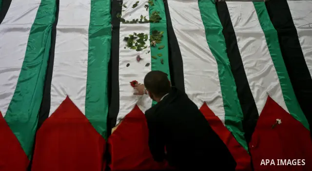 A view of flag-drapped coffins containing the remains of Palestinian militants after the arrival of the caskets in Gaza City, 31 May 2012. Israel handed over the remains of dozens of militants to the Palestinians, saying...