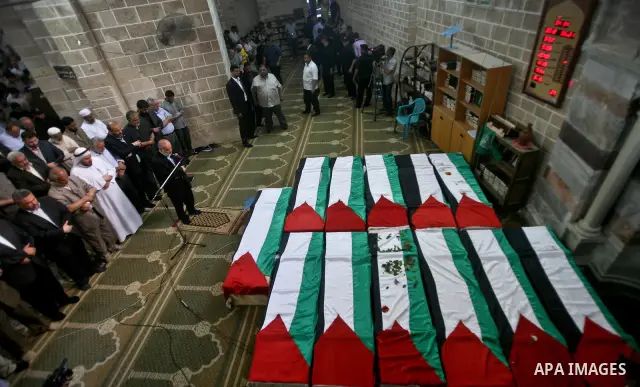 Palestinians pray next to flag-covered coffins containing the remains of Palestinian militants in a mosque in Gaza City May 31, 2012. The remains of 91 Palestinian militants whose attacks killed hundreds of Israelis over...