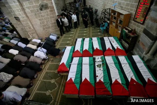 Palestinians pray next to flag-covered coffins containing the remains of Palestinian militants in a mosque in Gaza City May 31, 2012. The remains of 91 Palestinian militants whose attacks killed hundreds of Israelis over...