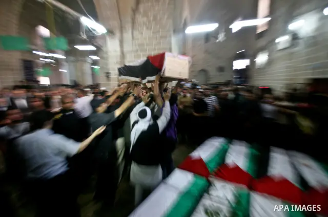 Palestinians pray next to flag-covered coffins containing the remains of Palestinian militants in a mosque in Gaza City May 31, 2012. The remains of 91 Palestinian militants whose attacks killed hundreds of Israelis over...