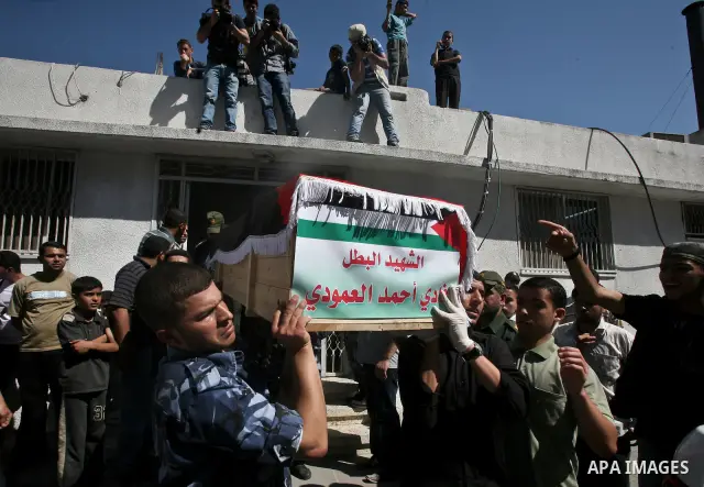 Palestinians carry a flag-covered coffin containing the remains of a Palestinian militant at a hospital in Gaza City May 31, 2012. The remains of 91 Palestinian militants whose attacks killed hundreds of Israelis were re...