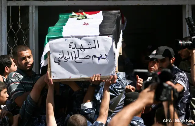 Palestinians carry a flag-covered coffin containing the remains of a Palestinian militant at a hospital in Gaza City May 31, 2012. The remains of 91 Palestinian militants whose attacks killed hundreds of Israelis were re...