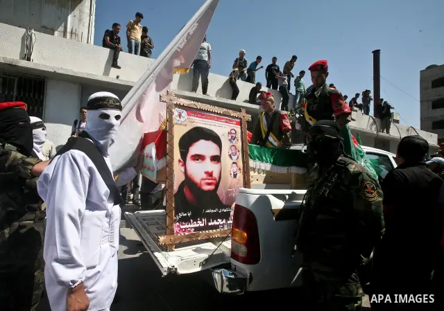 Palestinians carry a flag-covered coffin containing the remains of a Palestinian militant at a hospital in Gaza City May 31, 2012. The remains of 91 Palestinian militants whose attacks killed hundreds of Israelis were re...