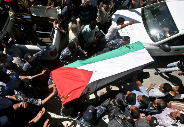 Relatives and masked Palestinian militants carry flag-drapped coffins containing the remains of Palestinian militants after the arrival of the caskets in Gaza City, 31 May 2012. Israel handed over the remains of dozens o...