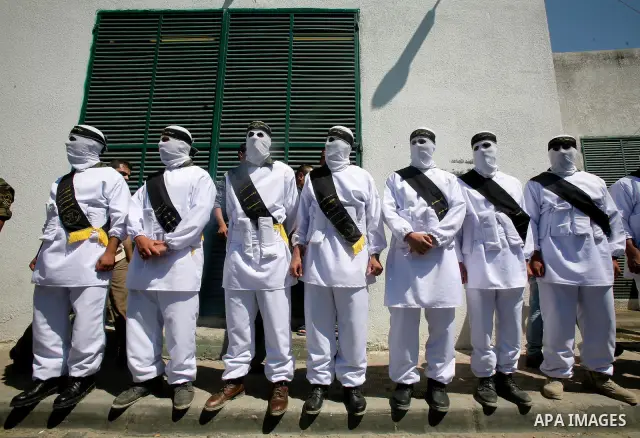 Relatives and masked Palestinian militants carry flag-drapped coffins containing the remains of Palestinian militants after the arrival of the caskets in Gaza City, 31 May 2012. Israel handed over the remains of dozens o...