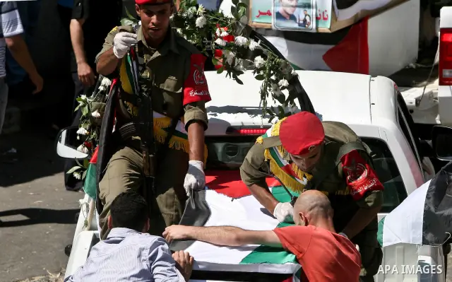Relatives and masked Palestinian militants carry flag-drapped coffins containing the remains of Palestinian militants after the arrival of the caskets in Gaza City, 31 May 2012. Israel handed over the remains of dozens o...