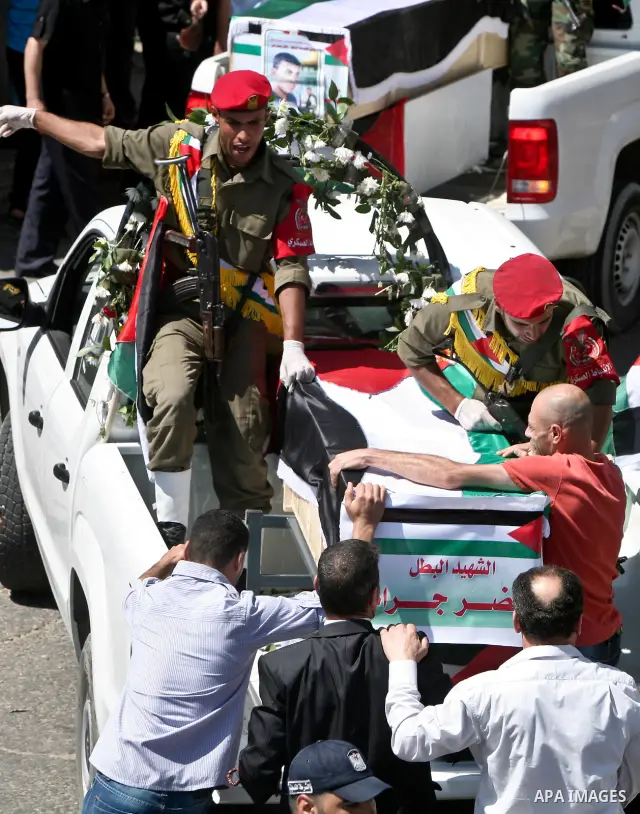Relatives and masked Palestinian militants carry flag-drapped coffins containing the remains of Palestinian militants after the arrival of the caskets in Gaza City, 31 May 2012. Israel handed over the remains of dozens o...
