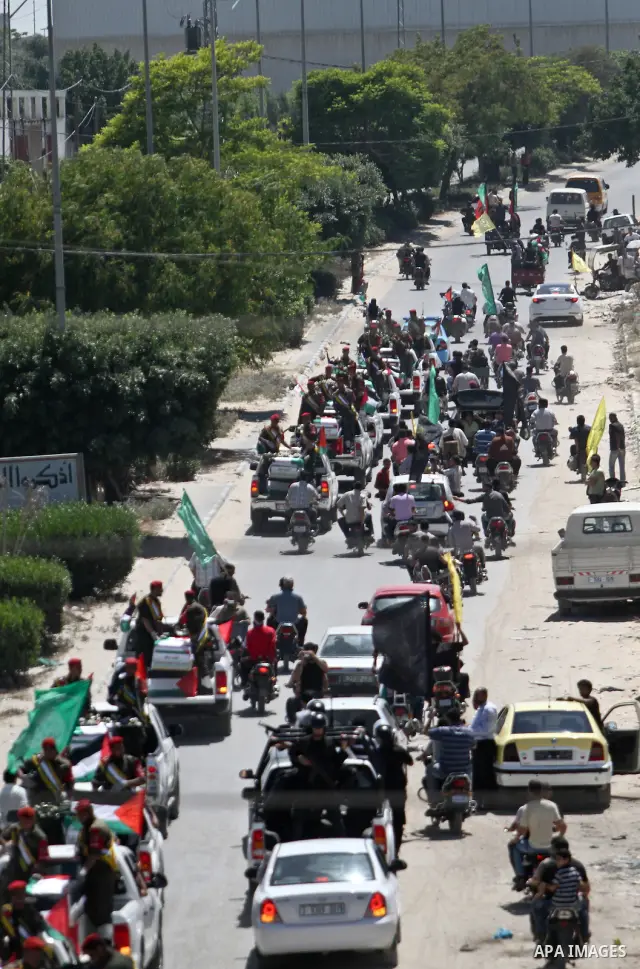 Relatives and masked Palestinian militants carry flag-drapped coffins containing the remains of Palestinian militants after the arrival of the caskets in Gaza City, 31 May 2012. Israel handed over the remains of dozens o...