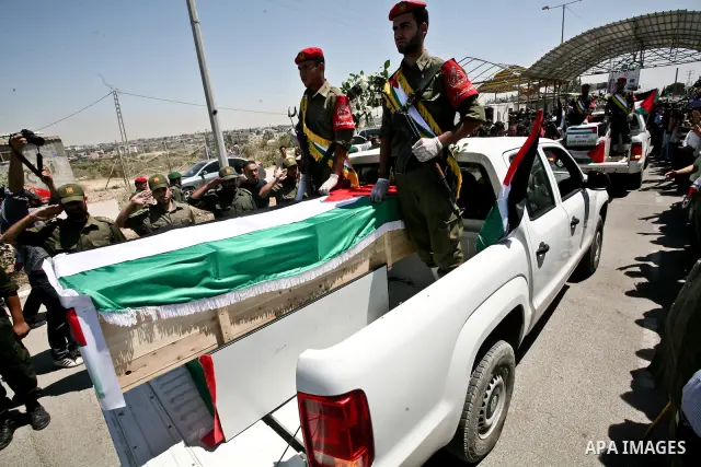 Relatives and masked Palestinian militants carry flag-drapped coffins containing the remains of Palestinian militants after the arrival of the caskets in Gaza City, 31 May 2012. Israel handed over the remains of dozens o...