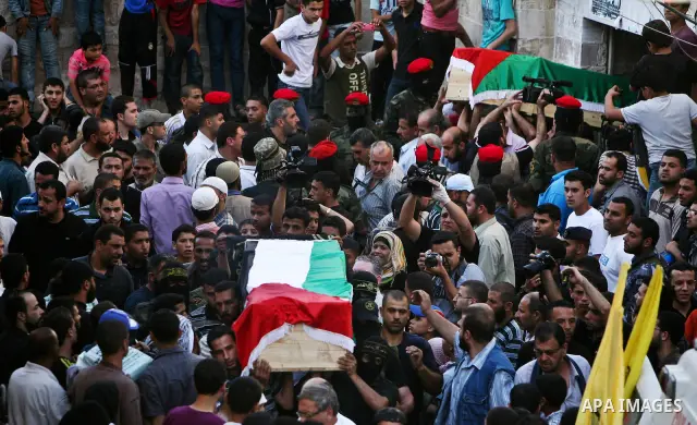 Relatives and masked Palestinian militants carry flag-drapped coffins containing the remains of Palestinian militants after the arrival of the caskets in Gaza City, 31 May 2012. Israel handed over the remains of dozens o...