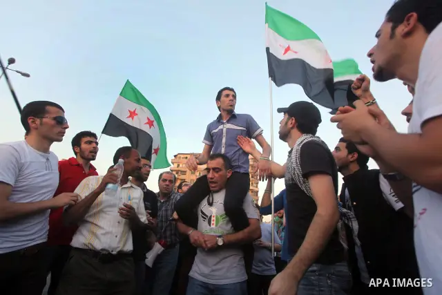 Syrians living in Egypt wave the revolutionary flag and shout slogans as they protest against the weekend massacre of Houla, in front of the Syrian embassy in Cairo, Egypt, 31 May 2012. A massacre was reported in the cen...