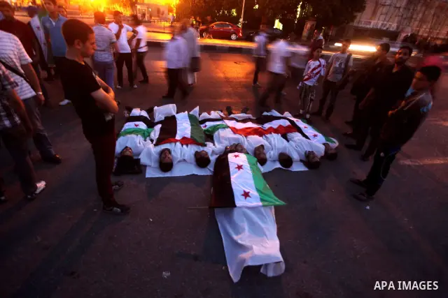 Protesters show solidarity with victims of massacre of Houla during a protest in front of the Syrian embassy in Cairo, Egypt, 31 May 2012. A massacre was reported in the central Syrian city of Houla over the weekend, how...