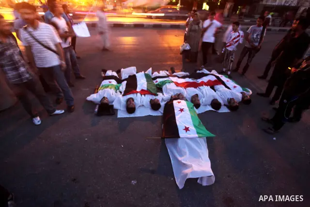 Protesters show solidarity with victims of massacre of Houla during a protest in front of the Syrian embassy in Cairo, Egypt, 31 May 2012. A massacre was reported in the central Syrian city of Houla over the weekend, how...