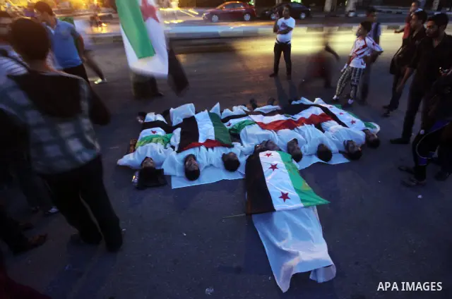 Protesters show solidarity with victims of massacre of Houla during a protest in front of the Syrian embassy in Cairo, Egypt, 31 May 2012. A massacre was reported in the central Syrian city of Houla over the weekend, how...