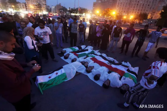 Protesters show solidarity with victims of massacre of Houla during a protest in front of the Syrian embassy in Cairo, Egypt, 31 May 2012. A massacre was reported in the central Syrian city of Houla over the weekend, how...