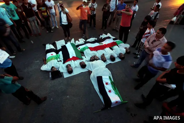 Protesters show solidarity with victims of massacre of Houla during a protest in front of the Syrian embassy in Cairo, Egypt, 31 May 2012. A massacre was reported in the central Syrian city of Houla over the weekend, how...