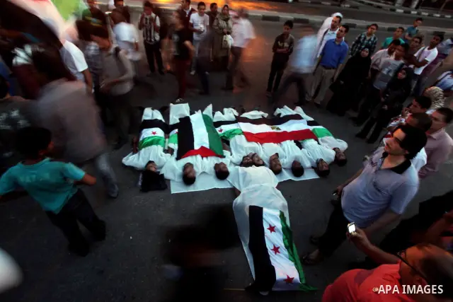 Protesters show solidarity with victims of massacre of Houla during a protest in front of the Syrian embassy in Cairo, Egypt, 31 May 2012. A massacre was reported in the central Syrian city of Houla over the weekend, how...