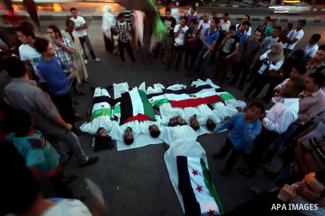 Protesters show solidarity with victims of massacre of Houla during a protest in front of the Syrian embassy in Cairo, Egypt, 31 May 2012. A massacre was reported in the central Syrian city of Houla over the weekend, how...