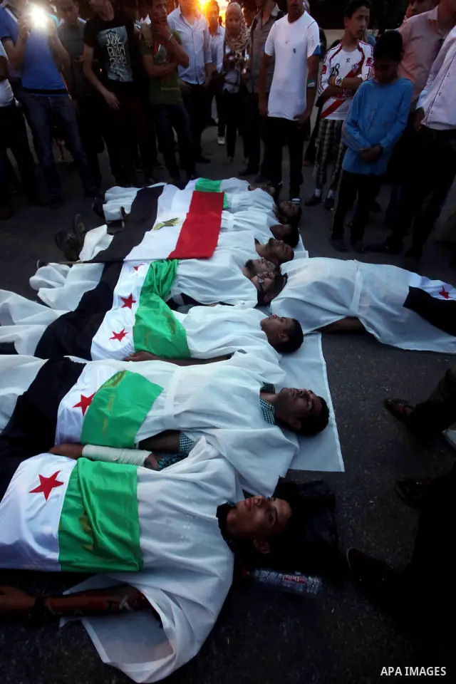 Protesters show solidarity with victims of massacre of Houla during a protest in front of the Syrian embassy in Cairo, Egypt, 31 May 2012. A massacre was reported in the central Syrian city of Houla over the weekend, how...
