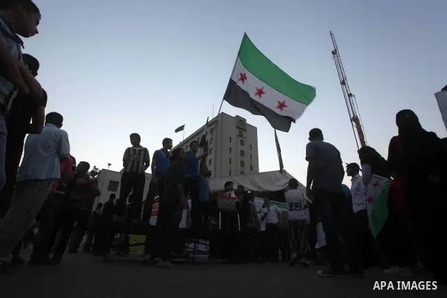 Protesters wave the revolutionary flag and shout slogans as they protest against the weekend massacre of Houla, in front of the Syrian embassy in Cairo, Egypt, 31 May 2012. A massacre was reported in the central Syrian c...