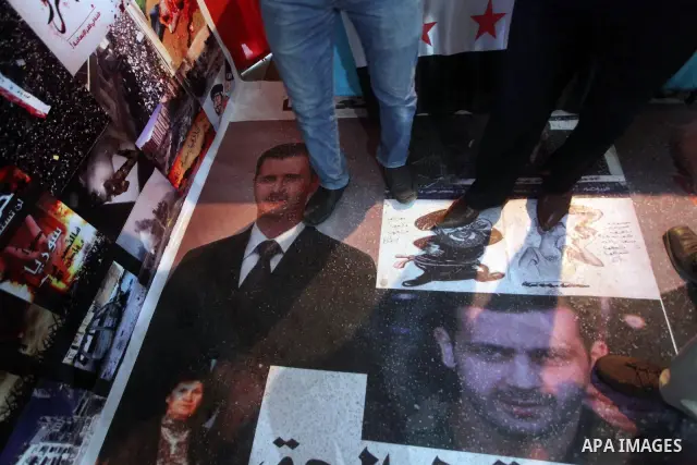 A protester tramples on the picture of Syrian President Bashar al-Assad during a protest against the weekend massacre of Houla, in front of the Syrian embassy in Cairo, Egypt, 31 May 2012. A massacre was reported in the...