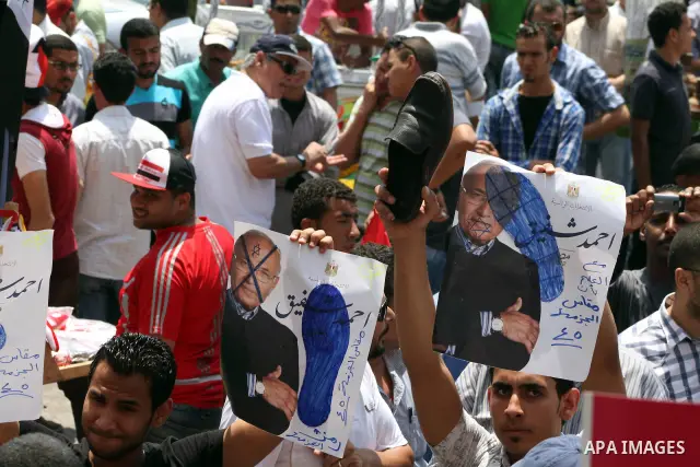 Egyptian protesters hold placards and shout slogans against the presidential candidate Ahmed Shafik, during a protest in Tahrir Square, Cairo, Egypt, 01 June 2012. Media reports state that hundreds of Egyptians held a de...