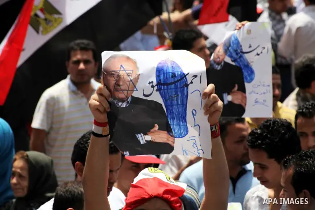Egyptian protesters hold placards and shout slogans against the presidential candidate Ahmed Shafik, during a protest in Tahrir Square, Cairo, Egypt, 01 June 2012. Media reports state that hundreds of Egyptians held a de...