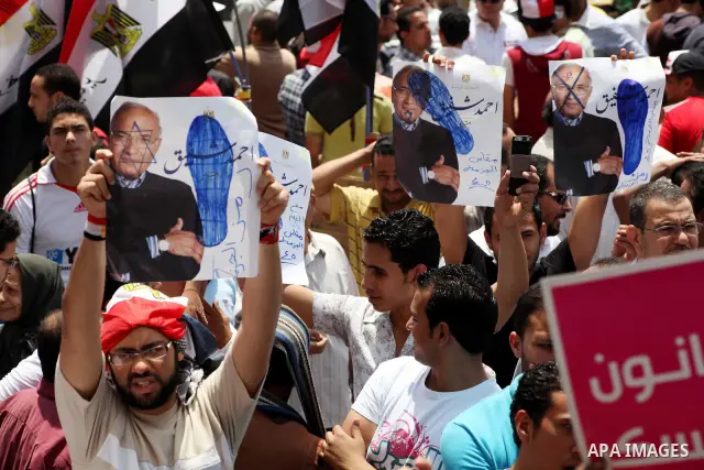 Egyptian protesters hold placards and shout slogans against the presidential candidate Ahmed Shafik, during a protest in Tahrir Square, Cairo, Egypt, 01 June 2012. Media reports state that hundreds of Egyptians held a de...