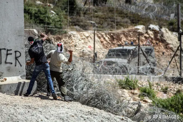 Palestinian protesters hurl stones at Israeli soldiers during a weekly demonstration against Israel's controversial separation barrier in the West Bank village of Nilin on June 1, 2012. When completed, 85 percent of the...