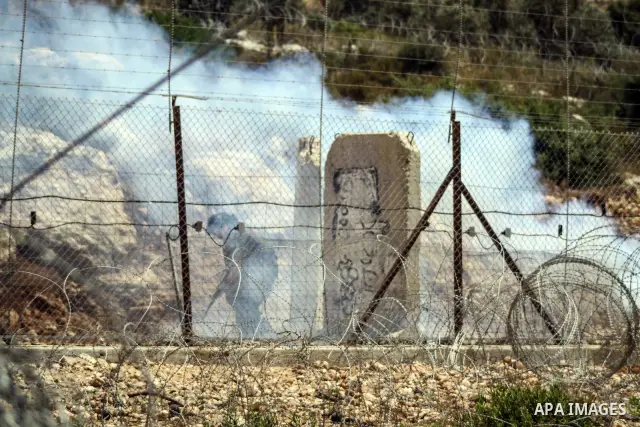Israeli soldier fire tear gas towards Palestinian protesters during a weekly demonstration against Israel's controversial separation barrier in the West Bank village of Nilin on June 1, 2012. When completed, 85 percent o...