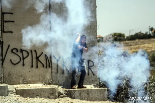 Palestinian protester hurls stones at Israeli soldiers during a weekly demonstration against Israel's controversial separation barrier in the West Bank village of Nilin on June 1, 2012. When completed, 85 percent of the...