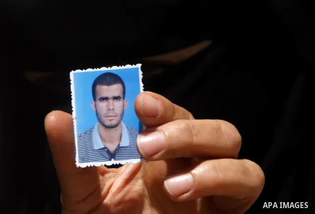 A relative of Ahmed Abu Nasr shows his photograph at his home in Khan Younis Refugee Camp, Friday, June 1, 2012. Abu Nasr and an Israeli soldier were killed in a shootout near the border with the Gaza Strip early Friday,...