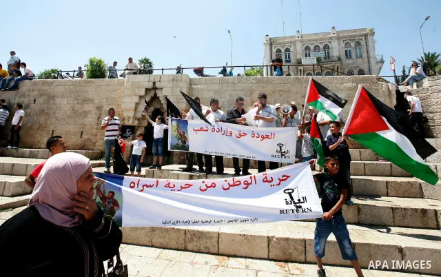 Palestinians hold national flag and shout slogans during a protest against continuing of 'Judaization of Jerusalem' by Jewish settlers and confiscating Palestinian lands at Al Tur and Damascus gate after Friday prayer in...