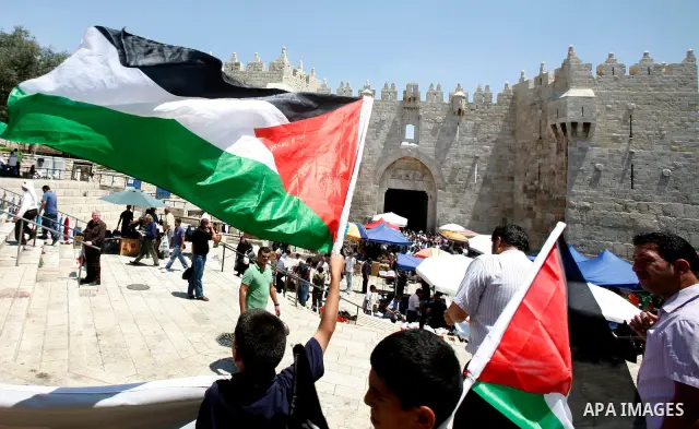 Palestinians hold national flag and shout slogans during a protest against continuing of 'Judaization of Jerusalem' by Jewish settlers and confiscating Palestinian lands at Al Tur and Damascus gate after Friday prayer in...
