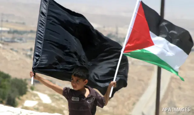 Palestinians hold national flag and shout slogans during a protest against continuing of 'Judaization of Jerusalem' by Jewish settlers and confiscating Palestinian lands at Al Tur and Damascus gate after Friday prayer in...