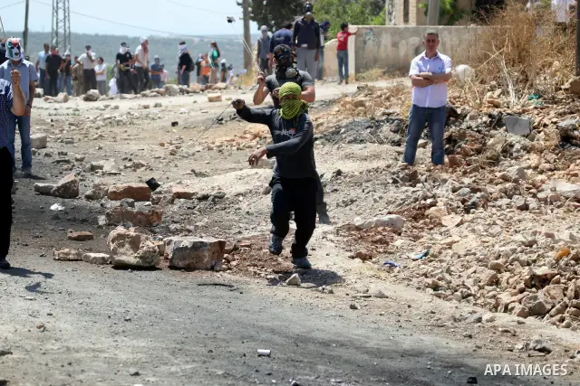 Palestinian protesters hurl a stones at Israeli soldiers during a demonstration against the expropriation of Palestinian land by Israel in the village of Kafr Qaddum, near the West Bank city of Nablus on June 1, 2012. Ph...