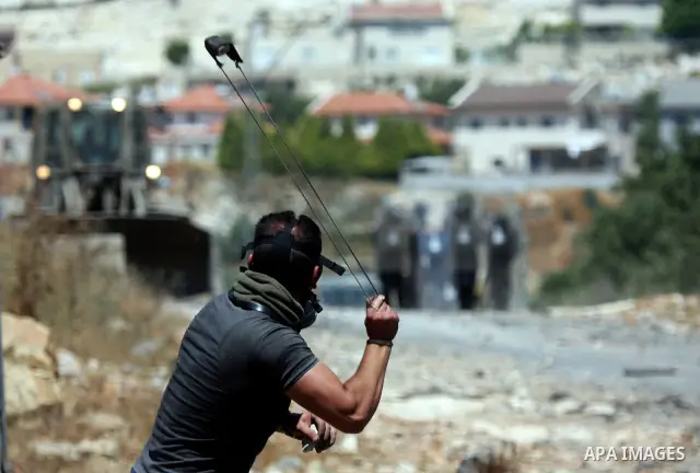 Palestinian protesters hurl a stones at Israeli soldiers during a demonstration against the expropriation of Palestinian land by Israel in the village of Kafr Qaddum, near the West Bank city of Nablus on June 1, 2012. Ph...