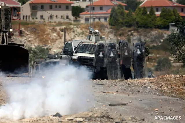 Israeli soldiers fire a tear gas canister at Palestinian protesters during a demonstration against the expropriation of Palestinian land by Israel in the village of Kafr Qaddum, near the West Bank city of Nablus on June...